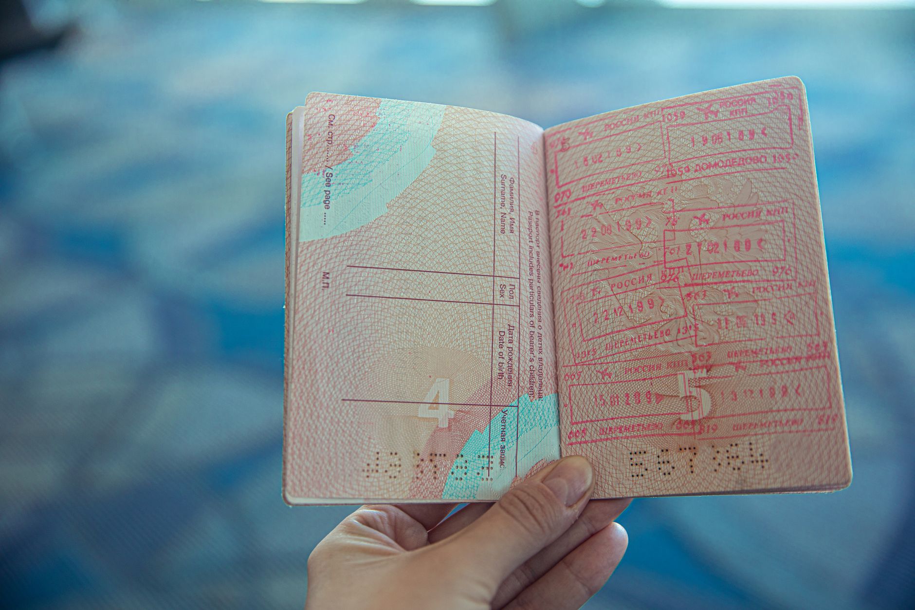 Närbild av ett öppet pass med inresestämplar på en flygplats