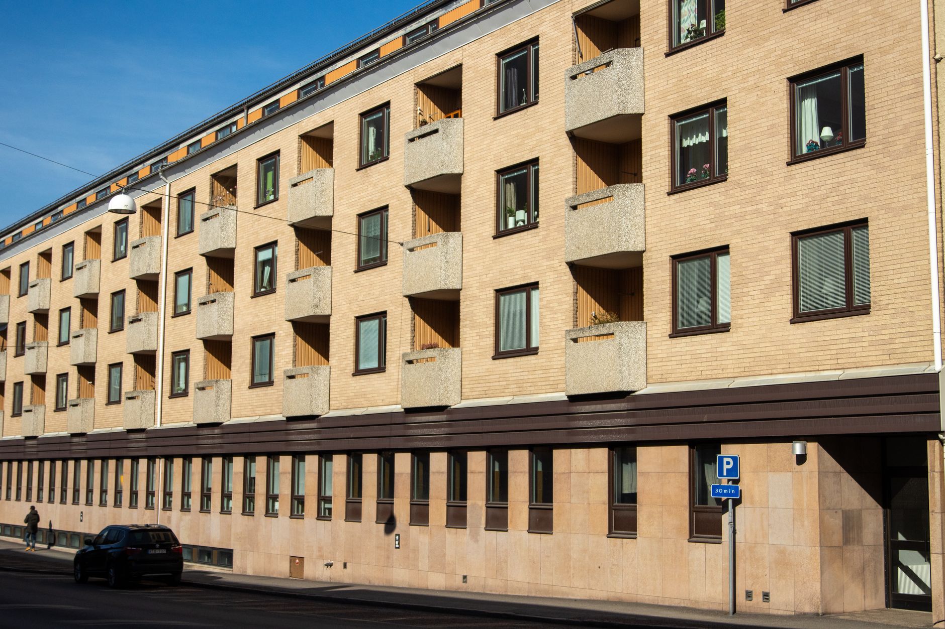 Ett modernt flerbostadshus med ljus fasad och balkonger i Jönköping.