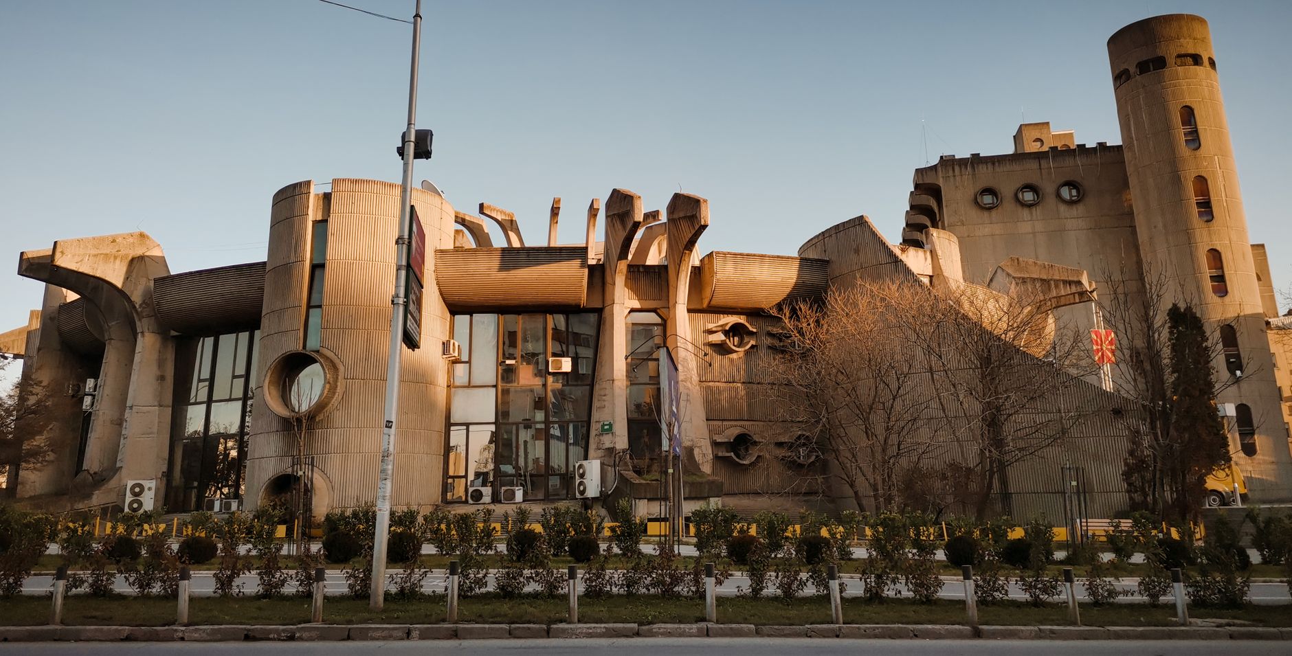 Det brutalistiska centralposthuset i Skopje i varmt kvällsljus.