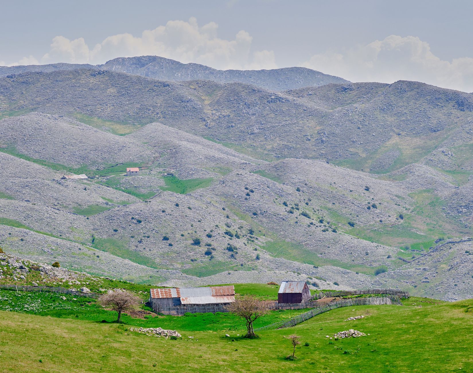 Ett rustikt stenhus på en bergssluttning i Albanien.